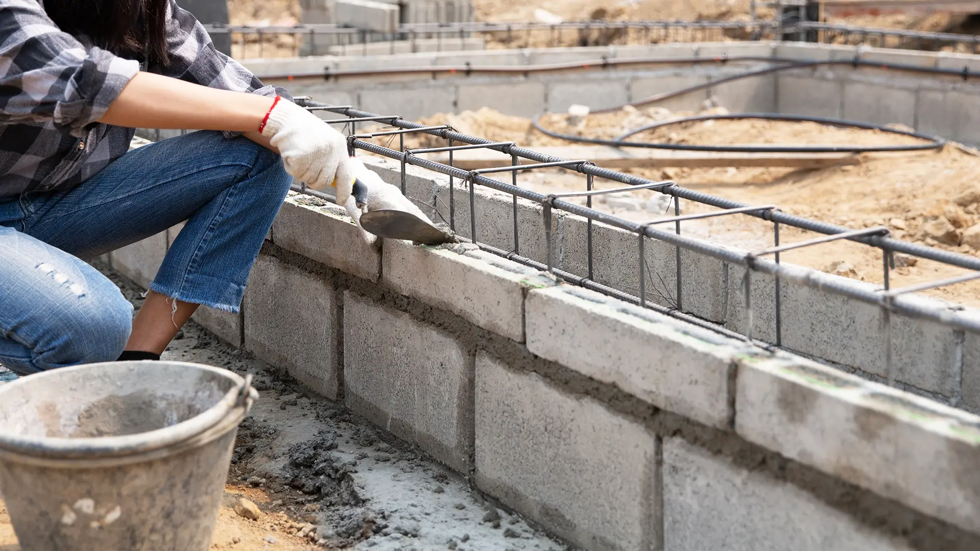 Bricklayer constructing a wall using concrete blocks