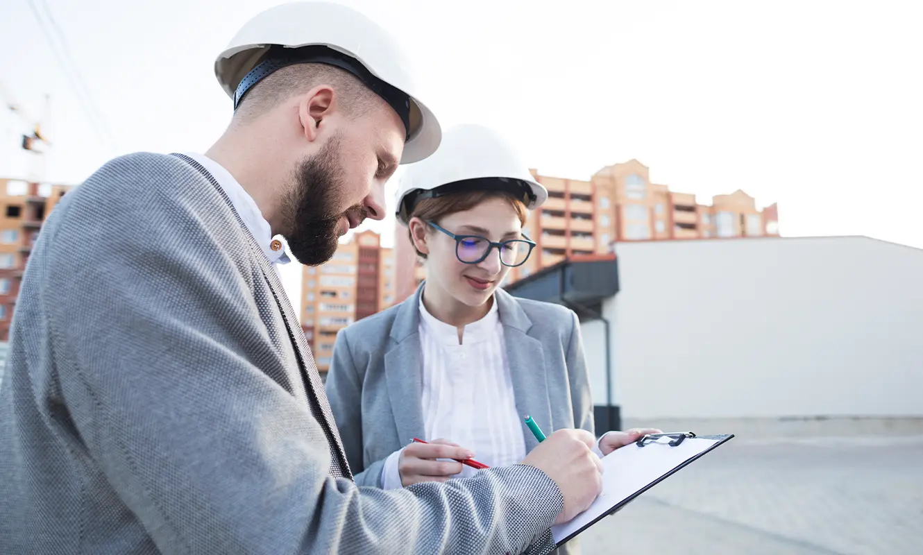 Engineering-Sydney-structural-expert-witness-reports Male and female reviewing building plans on site