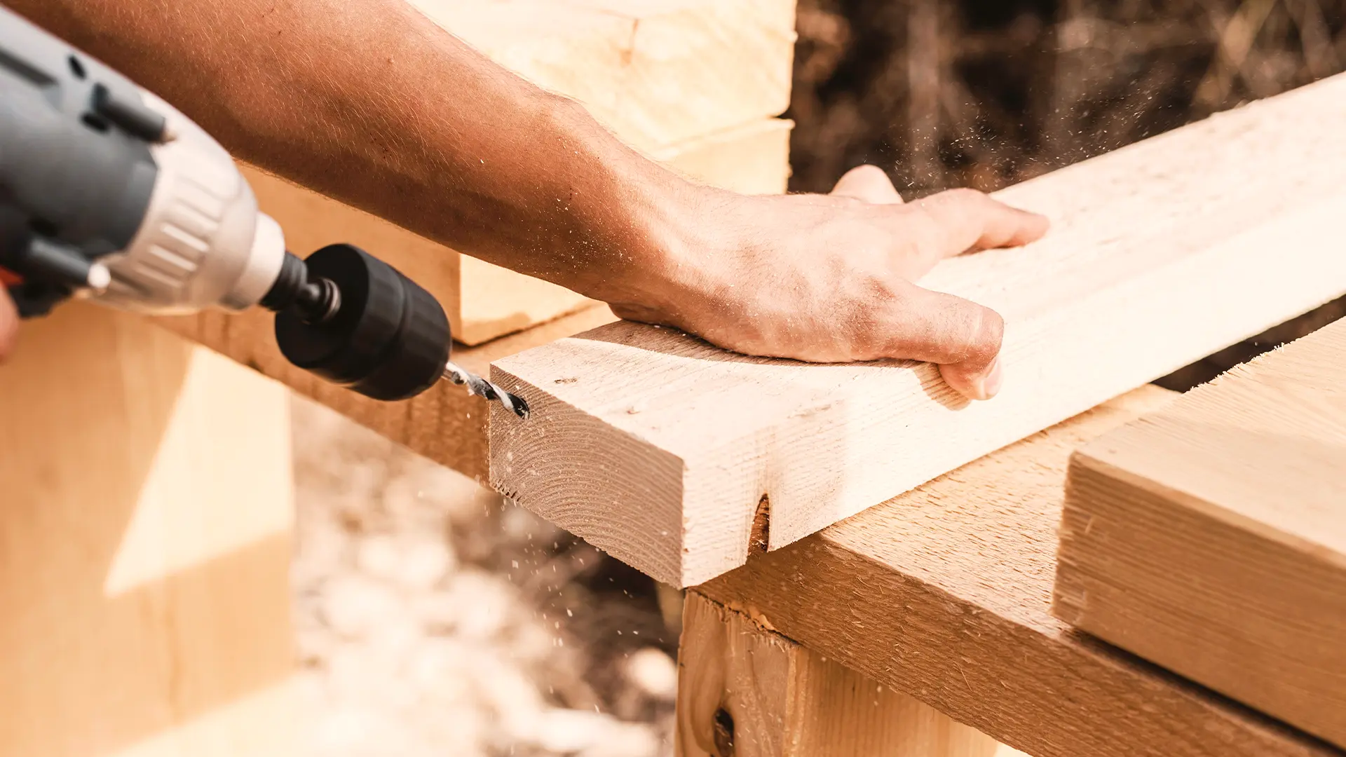 Male labourer drilling a piece of wood